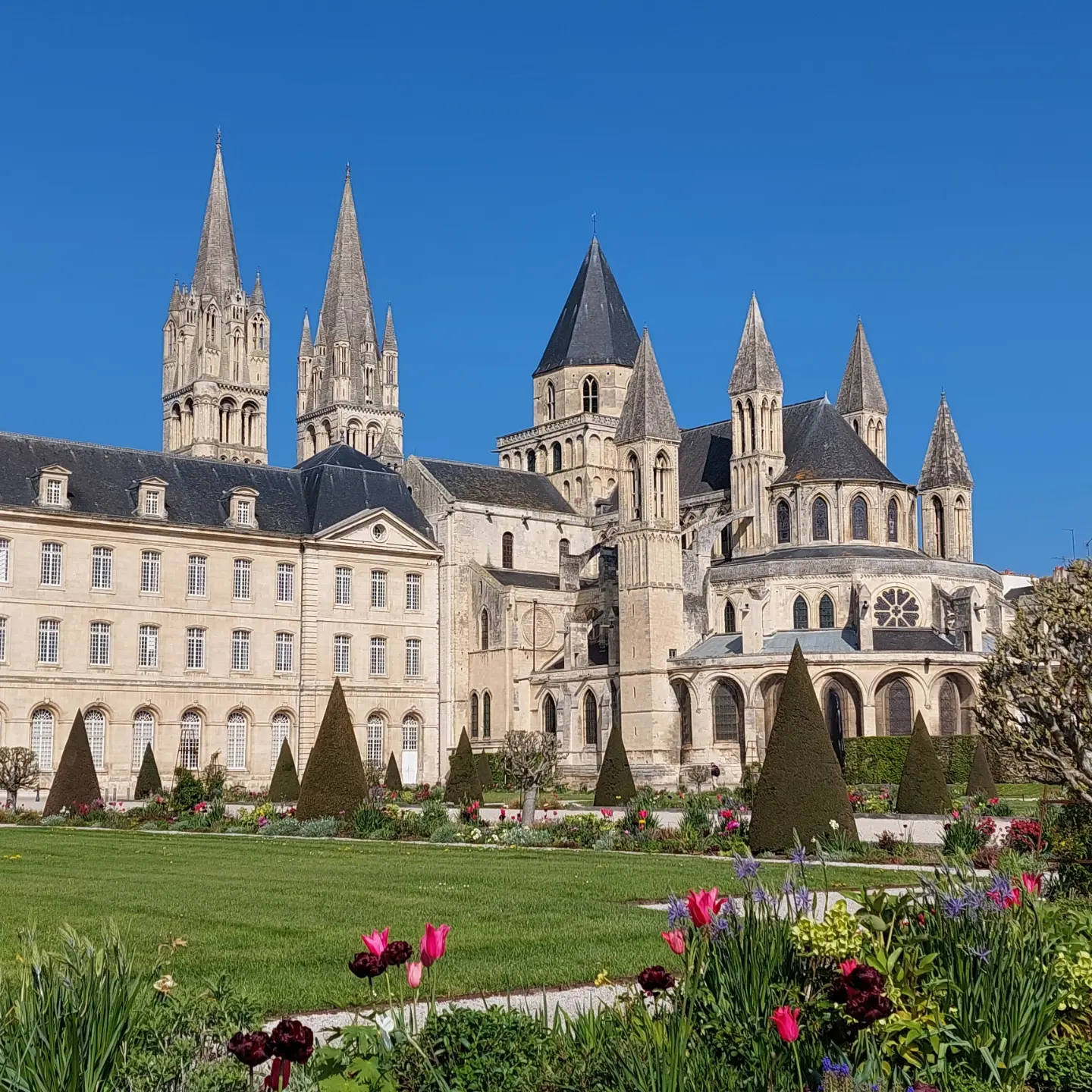 L'abbaye aux hommes à Caen contre un ciel bleu avec des jardins en premier plan